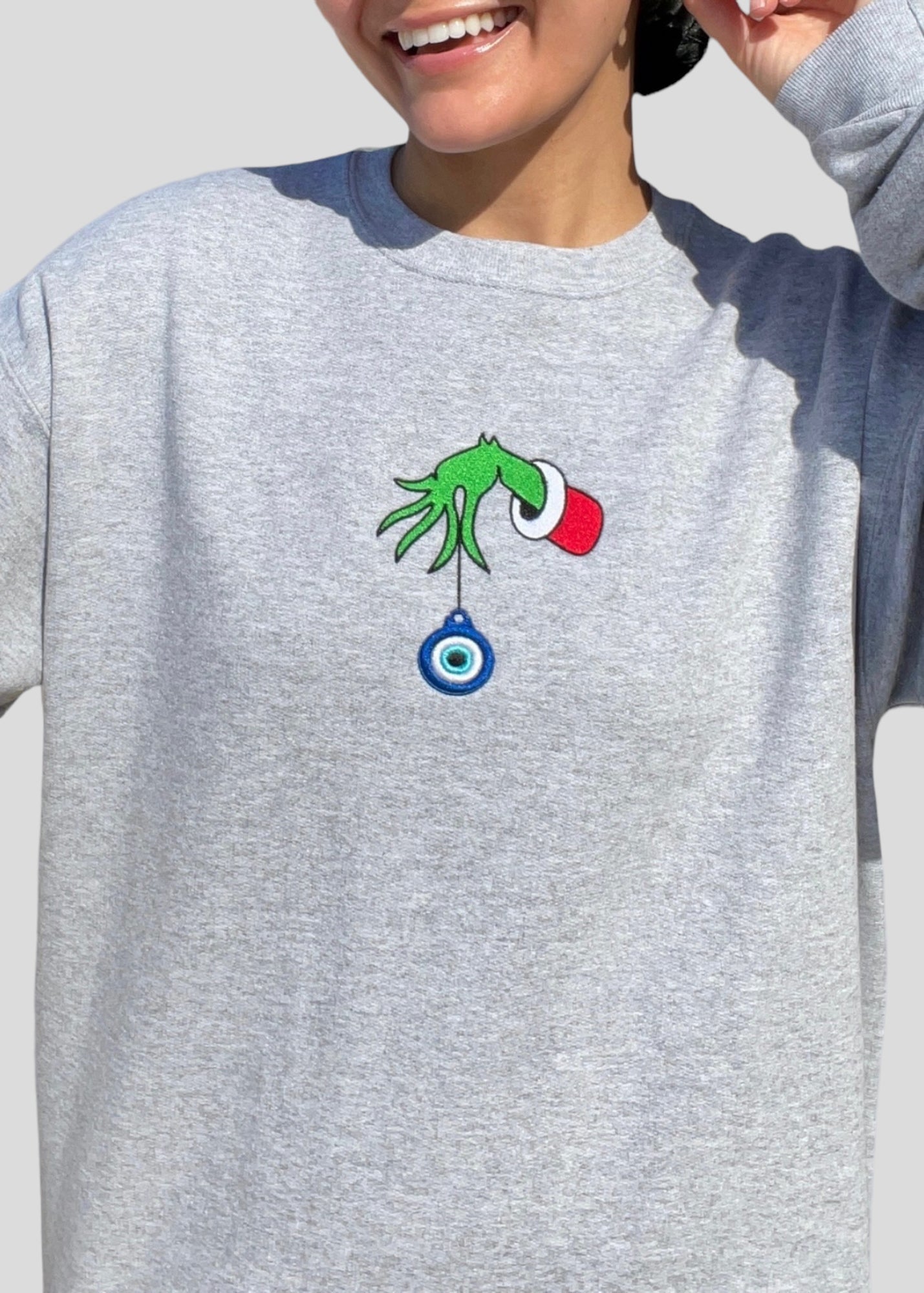 Embroidered Grinch Hand with Evil Eye Ornament Sweatshirts